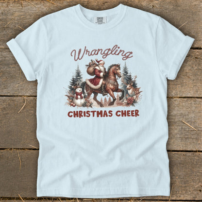Light blue t-shirt with Santa on horseback and "Wrangling Christmas Cheer" text.