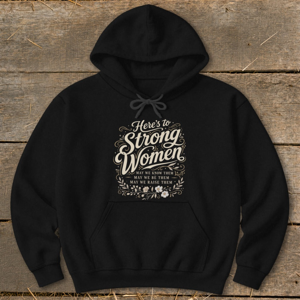Black hoodie with "Here's to Strong Women" text and floral accents.