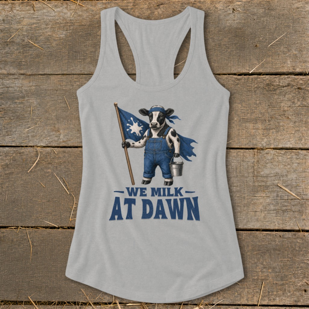 Cow in overalls and cape holding flag and milk bucket, text reads "WE MILK AT DAWN".