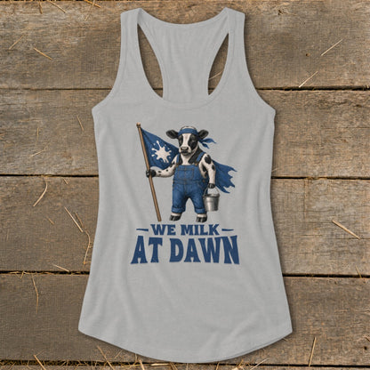 Cow in overalls and cape holding flag and milk bucket, text reads "WE MILK AT DAWN".