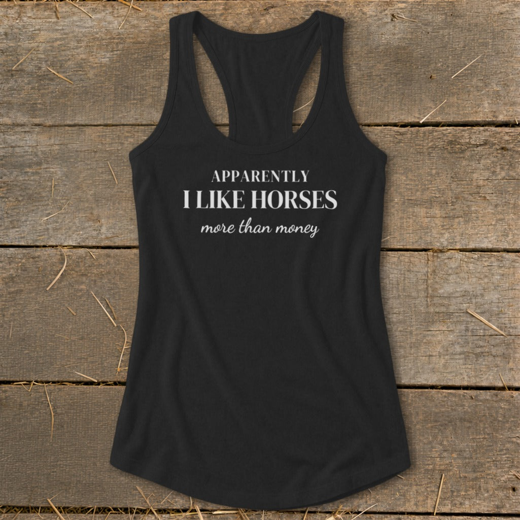 Black racerback tank top with white text: "APPARENTLY I LIKE HORSES more than money".