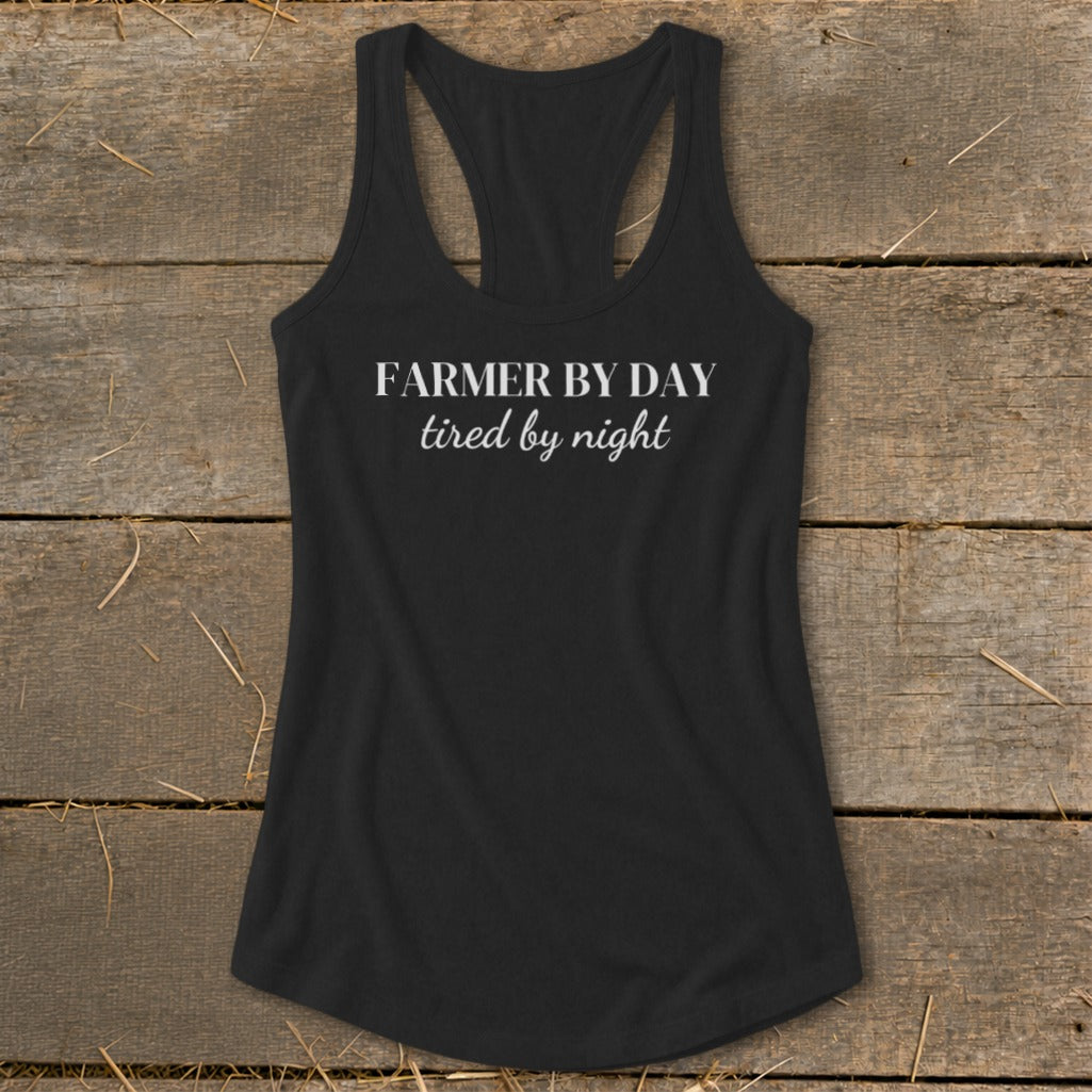Black racerback tank top with "FARMER BY DAY tired by night" text.