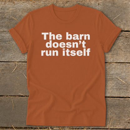 Orange t-shirt with white text that reads "The barn doesn't run itself".