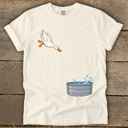 White t-shirt with cartoon of a duck jumping into a galvanized tub of water.
