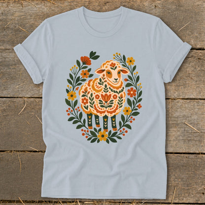 Light blue t-shirt with a folk art sheep illustration surrounded by floral wreath.