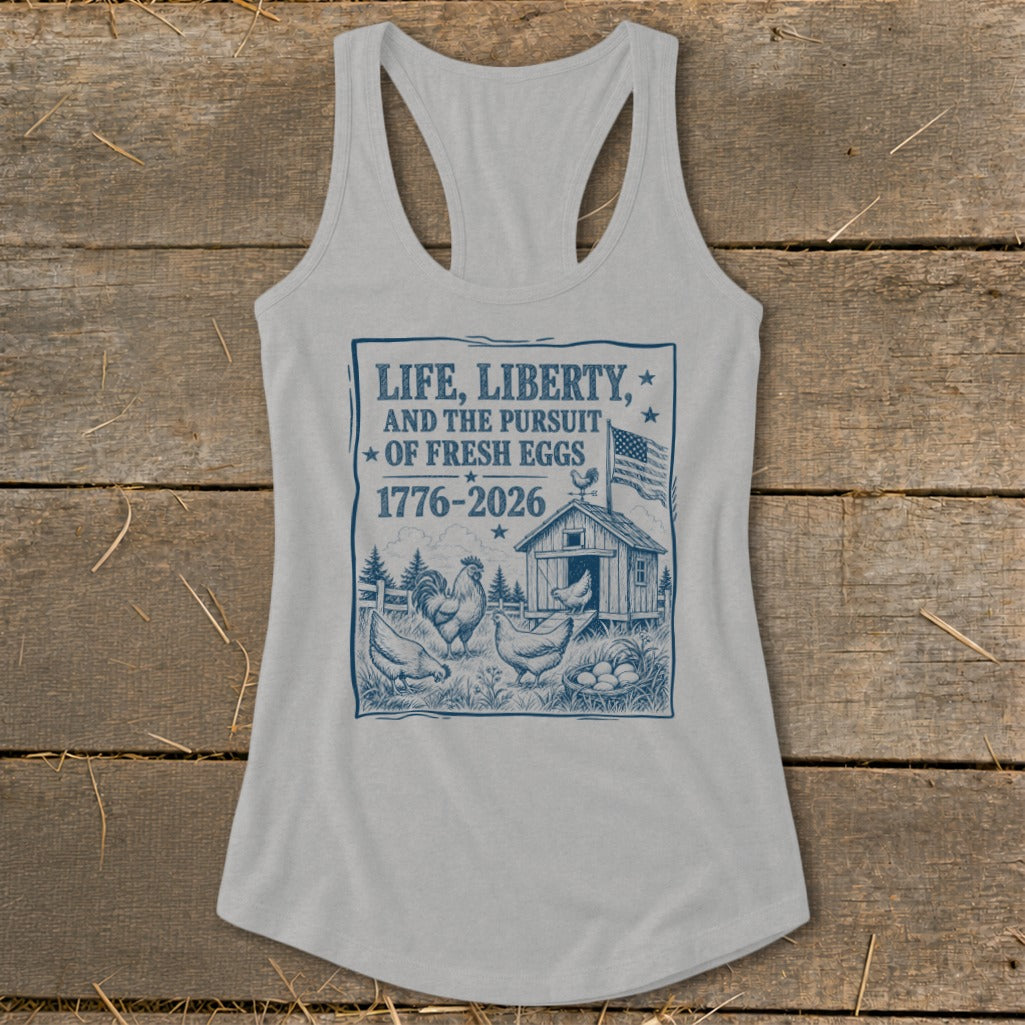 Light gray tank top with "Life, Liberty, and the Pursuit of Fresh Eggs 1776-2026" text.