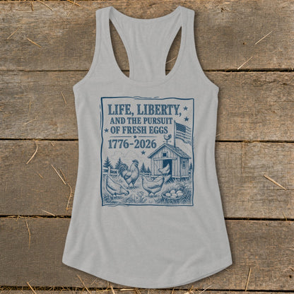 Light gray tank top with "Life, Liberty, and the Pursuit of Fresh Eggs 1776-2026" text.