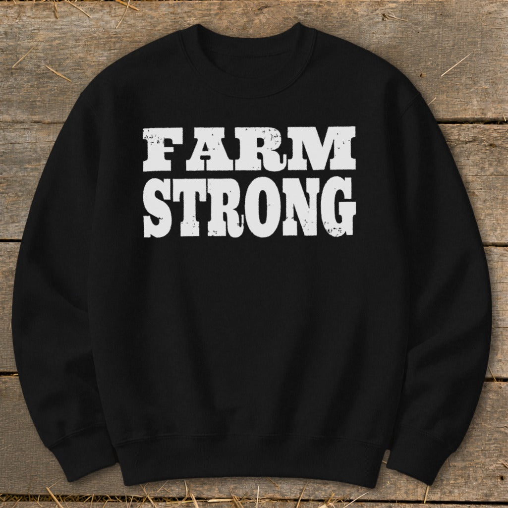A black crewneck sweatshirt with distressed white text reading FARM STRONG centered on the chest.