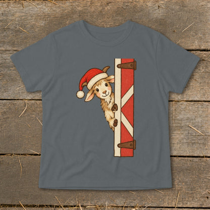 Goat wearing Santa hat peeks around a red barn door.