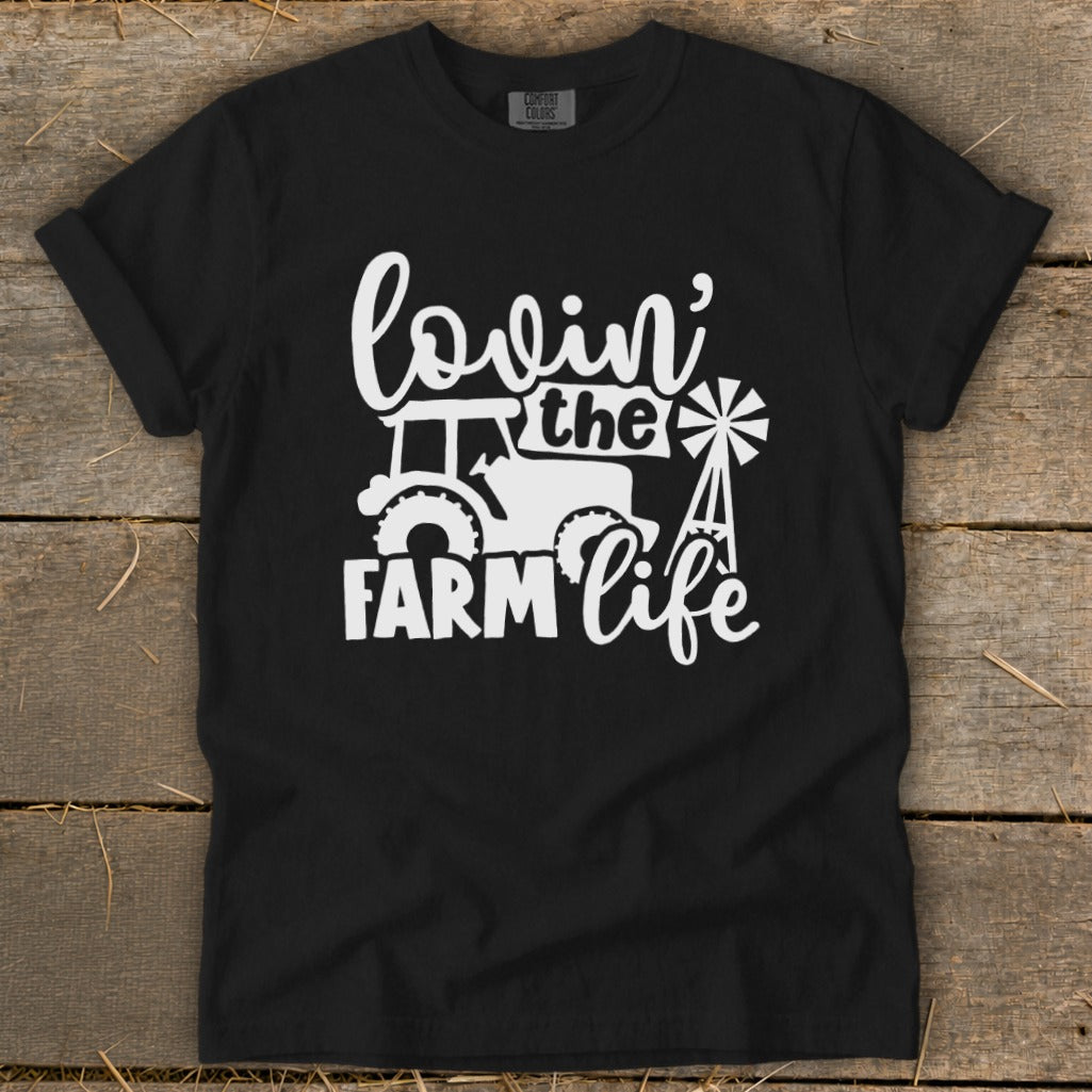 Black t-shirt with white graphic of tractor, windmill, and text "lovin' the FARM life".