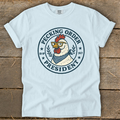 Light blue t-shirt with a chicken wearing glasses and a bandana, labeled "Pecking Order President".