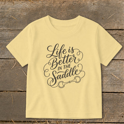 Yellow t-shirt with "Life is Better in the Saddle" text and horse bit graphic.