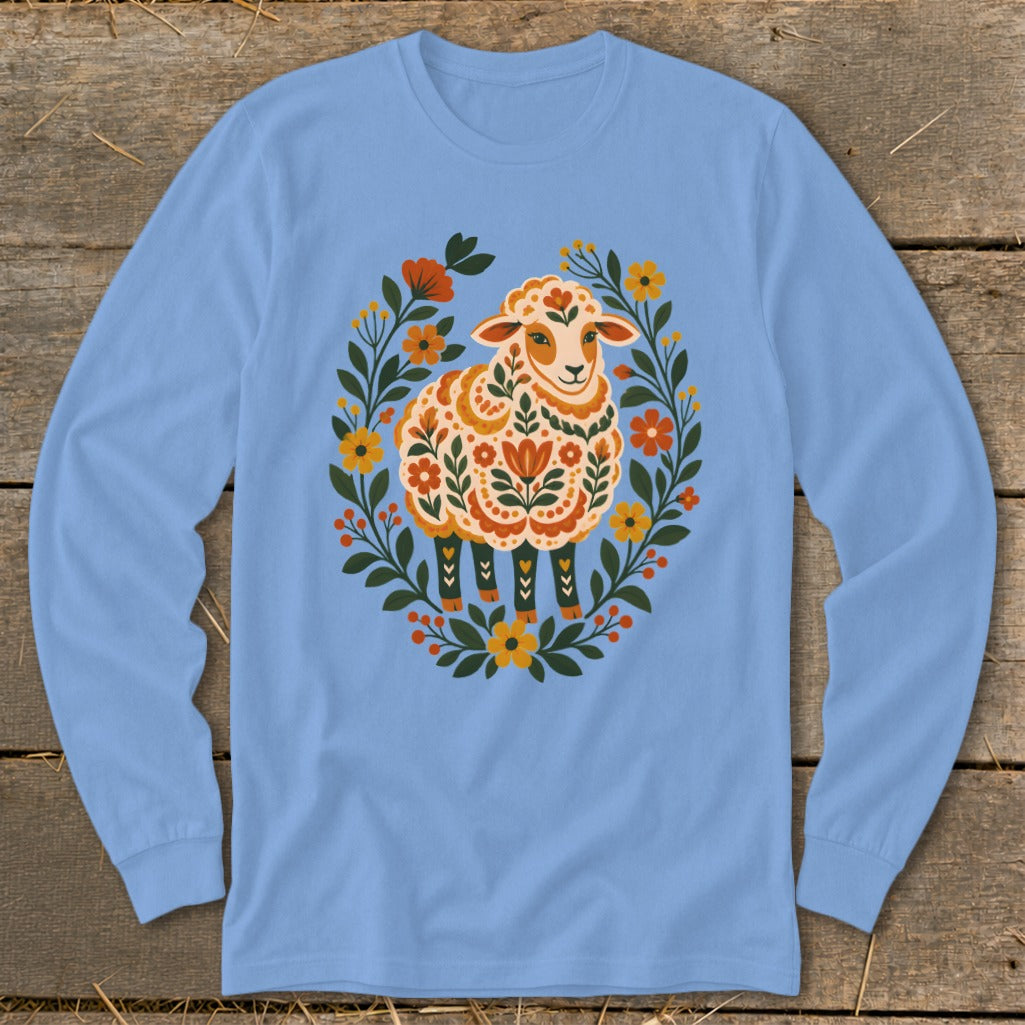 Light blue long sleeve shirt with a folk art sheep design surrounded by flowers.