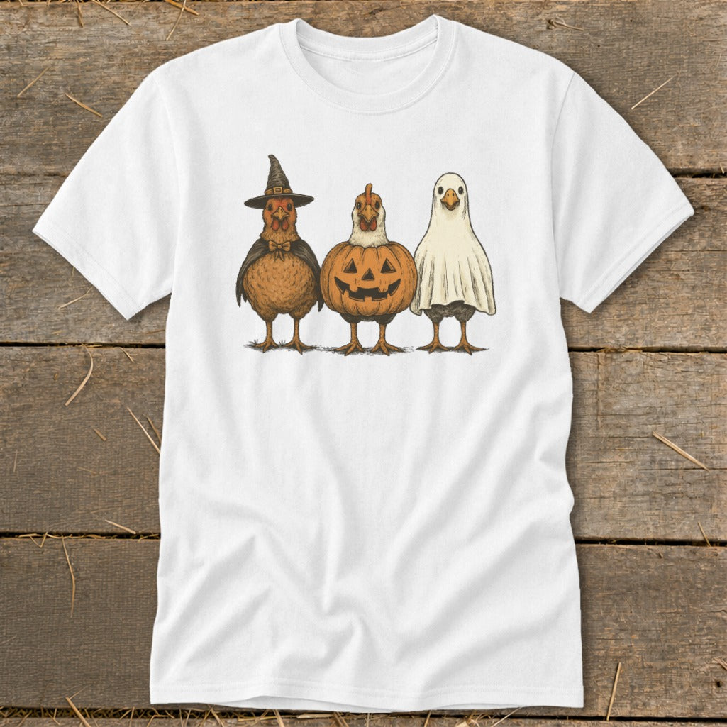 Three chickens dressed as a witch, a jack-o'-lantern, and a ghost on a white t-shirt.