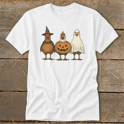 Three chickens dressed as a witch, a jack-o'-lantern, and a ghost on a white t-shirt.