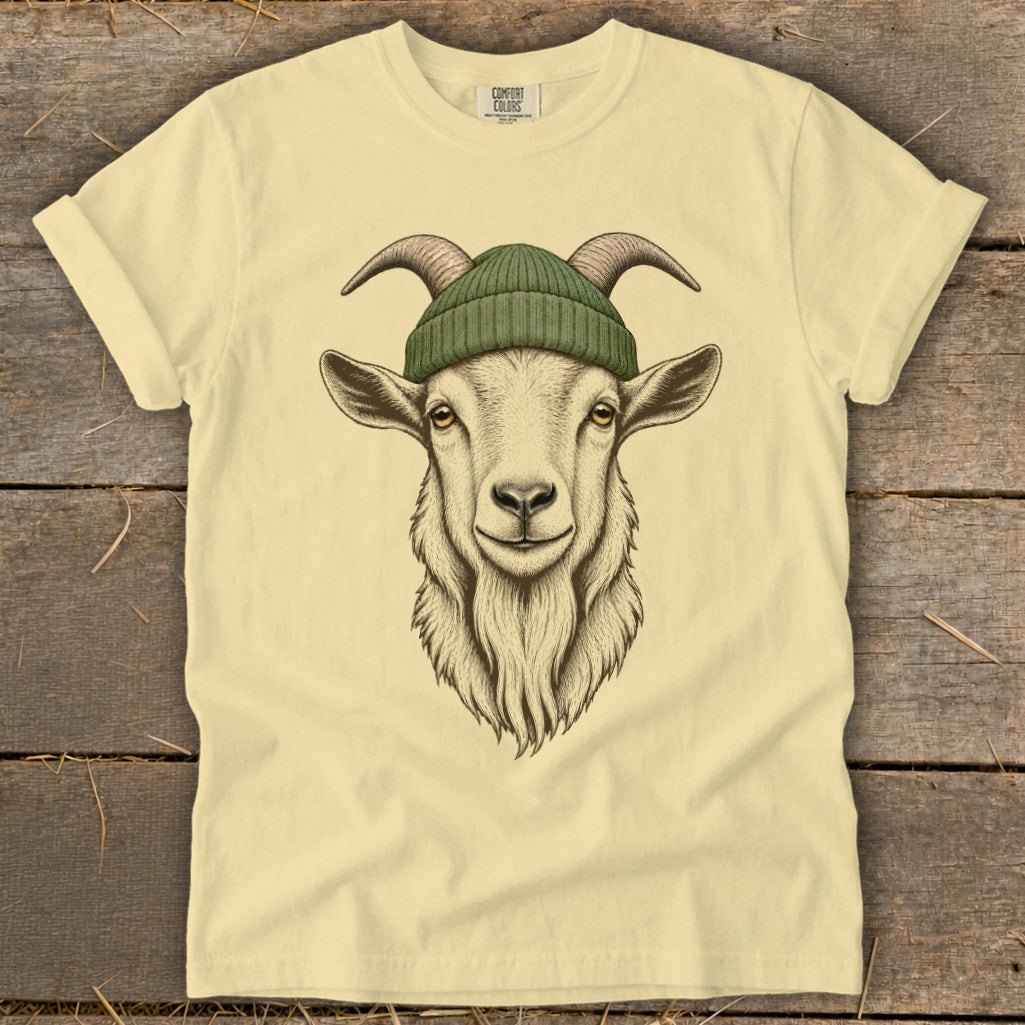 Cream t-shirt with a detailed illustration of a goat wearing a green beanie.