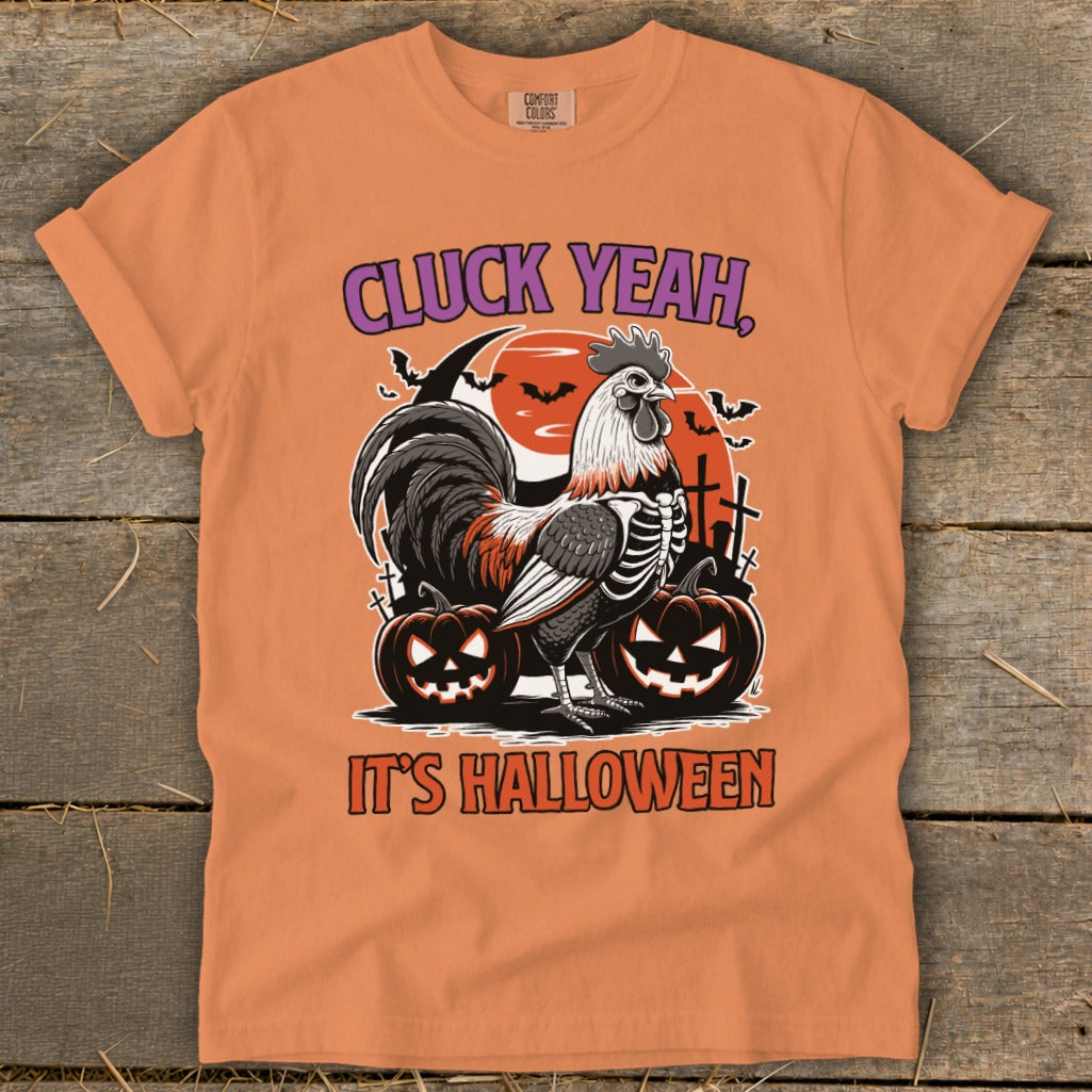 Orange t-shirt with skeleton rooster, pumpkins, and text "CLUCK YEAH, IT'S HALLOWEEN".