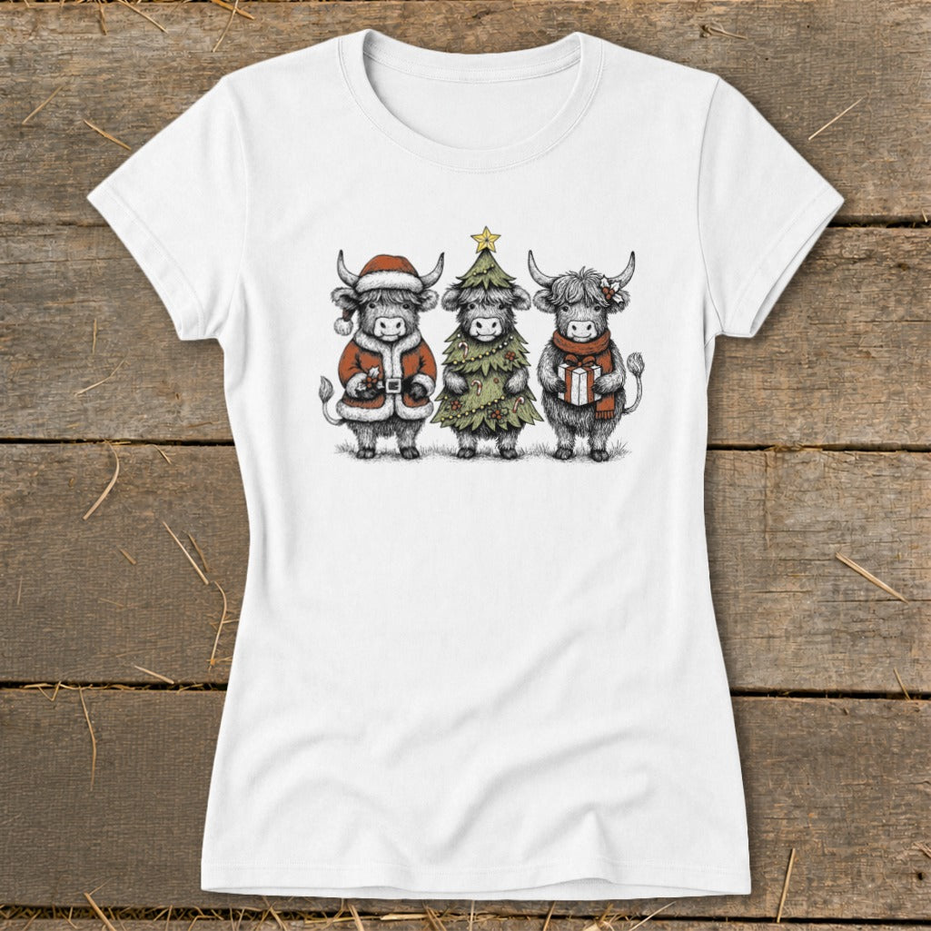 Three Highland cows in holiday attire on a white t-shirt.