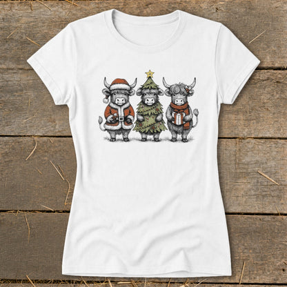 Three Highland cows in holiday attire on a white t-shirt.