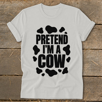 White t-shirt with black text reading "PRETEND I'M A COW" within cow spots.