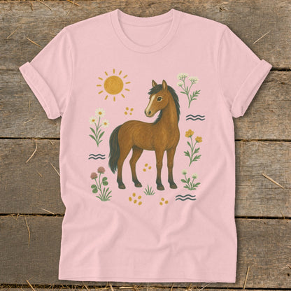 Pink t-shirt with a brown horse surrounded by flowers, sun, and wavy lines.