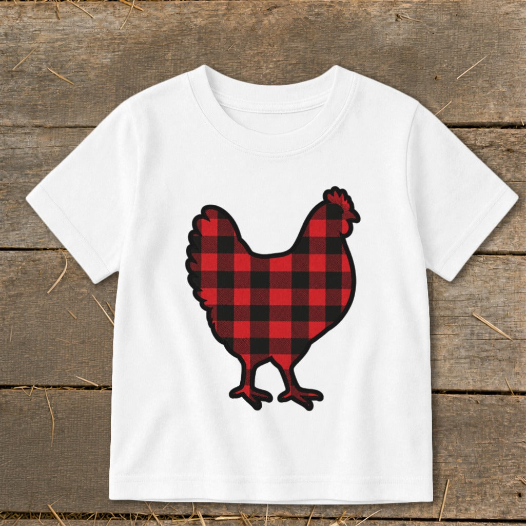 White t-shirt with a buffalo plaid chicken graphic on a wooden background.