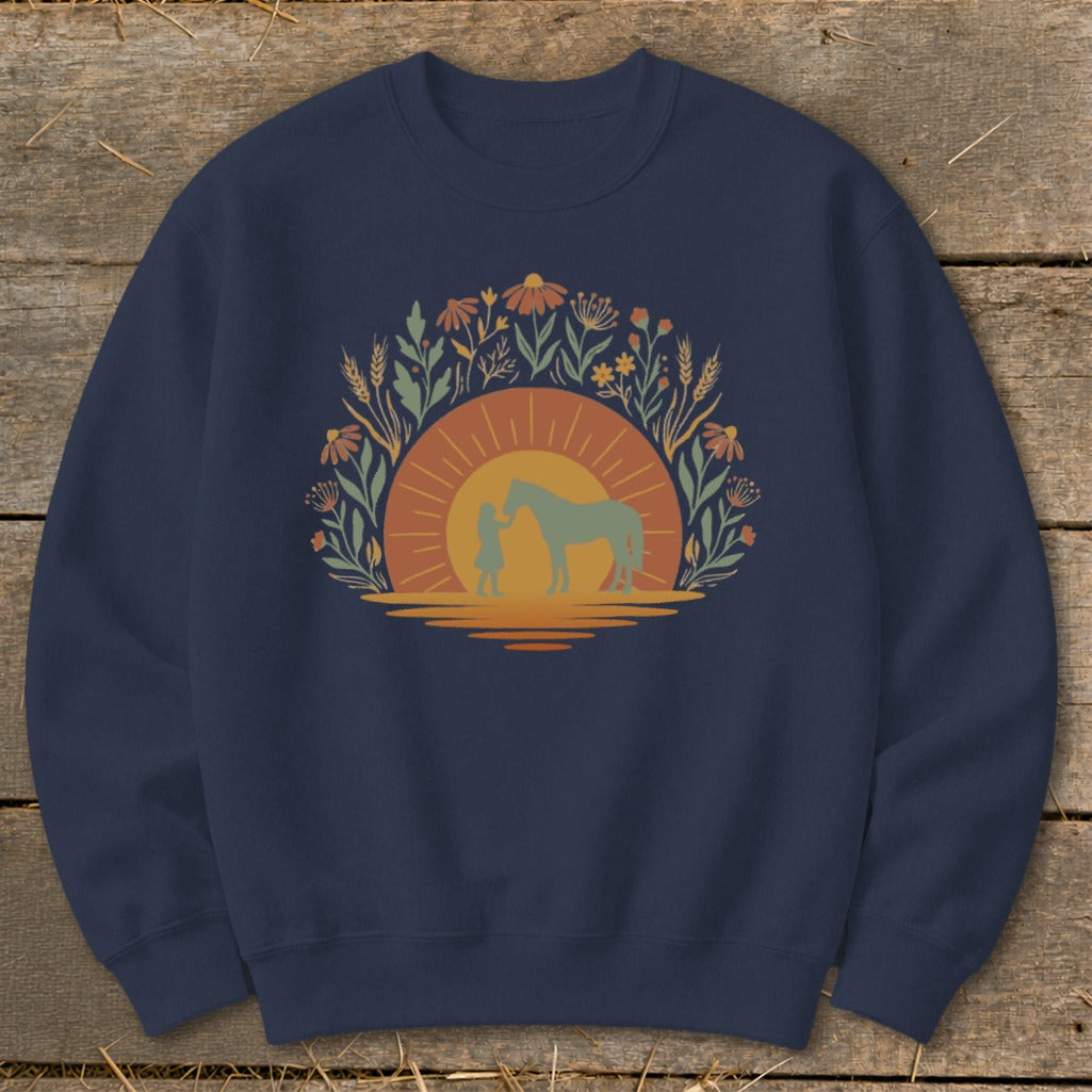 Crewneck sweatshirt with a sunset graphic featuring a person and a horse surrounded by floral elements.
