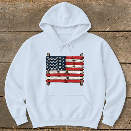 A white hooded sweatshirt features a graphic of an American flag made from weathered wooden planks and horseshoes.