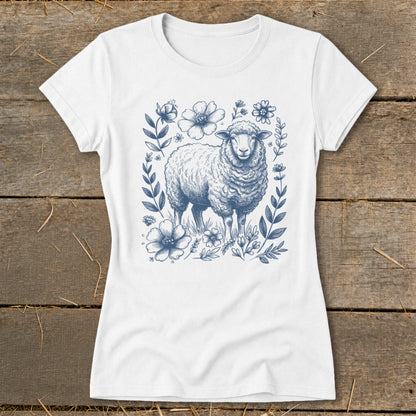White t-shirt with a blue sketch of a sheep surrounded by flowers and leaves.