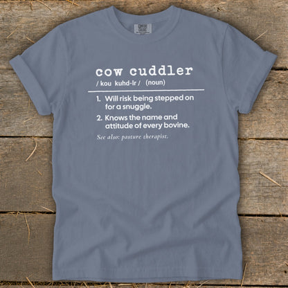 Blue t-shirt with "cow cuddler" definition, listing bravery and bovine knowledge.