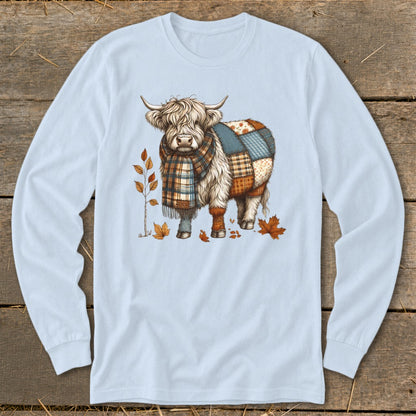 Illustration of a fluffy cow wearing a plaid scarf and patchwork coat, surrounded by autumn leaves.