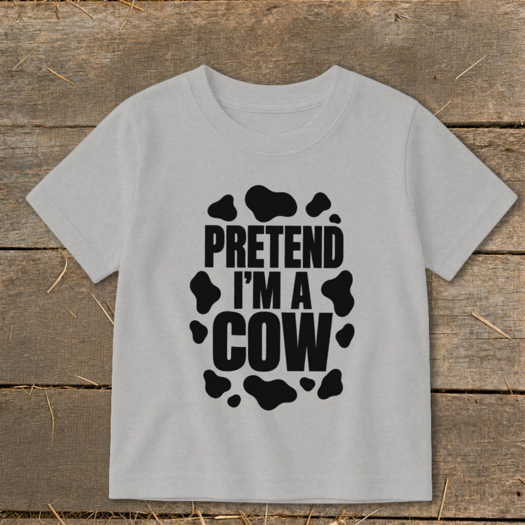 Light grey t-shirt with black cow spots and text "PRETEND I'M A COW".