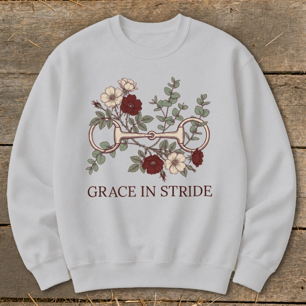 Light gray sweatshirt with a horse bit and floral graphic and text "GRACE IN STRIDE".