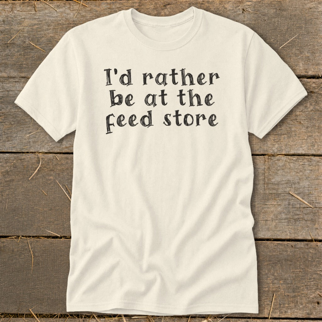 Cream t-shirt with black text reading "I'd rather be at the feed store".