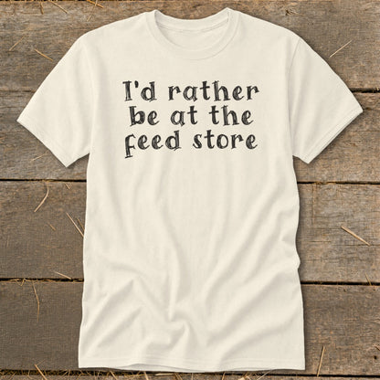 Cream t-shirt with black text reading "I'd rather be at the feed store".