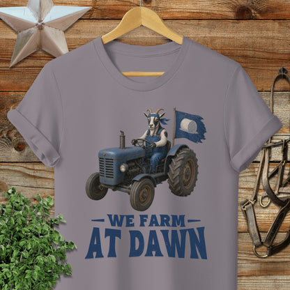 Goat driving a tractor with "WE FARM AT DAWN" text.