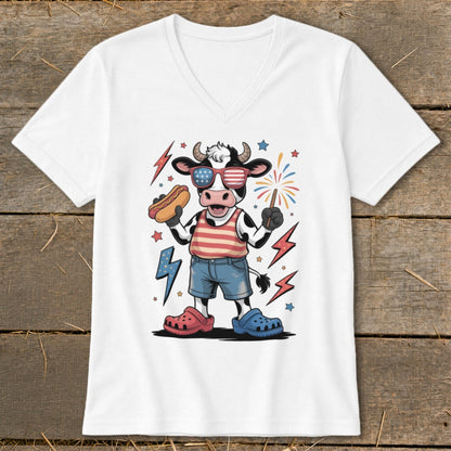 Cow with hot dog and sparkler wearing American flag sunglasses and striped shirt.