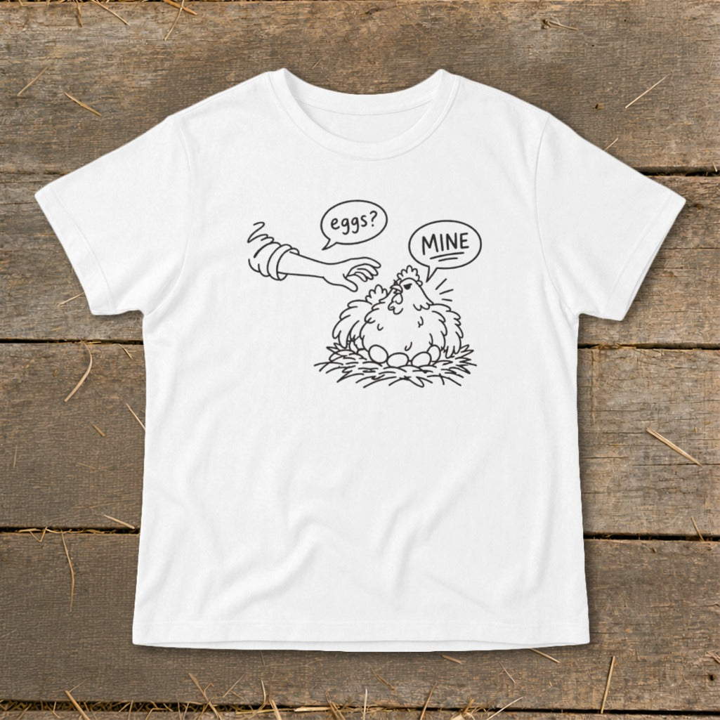 White t-shirt with cartoon of hen protecting eggs from hand asking "eggs?".