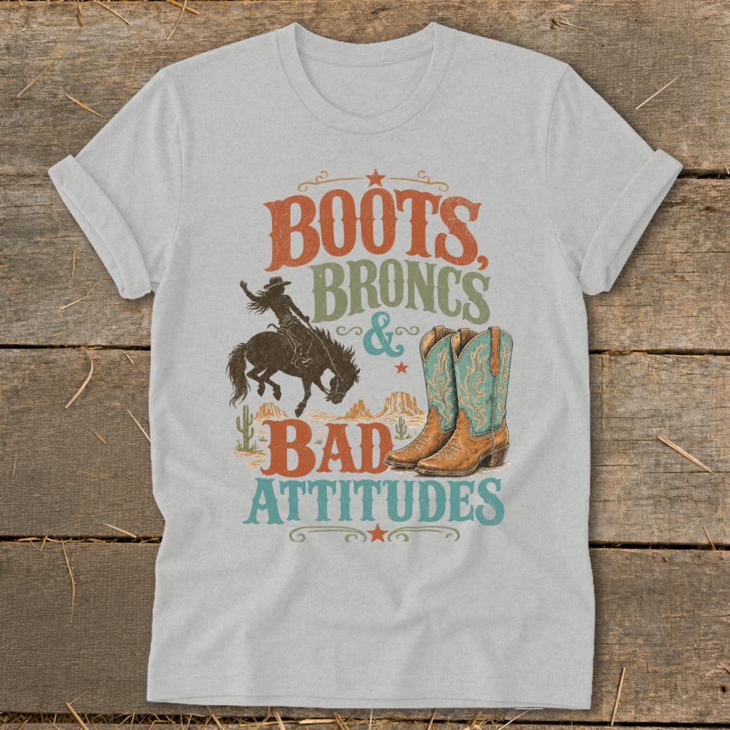 T-shirt graphic with text "Boots, Broncs & Bad Attitudes" and western illustrations.
