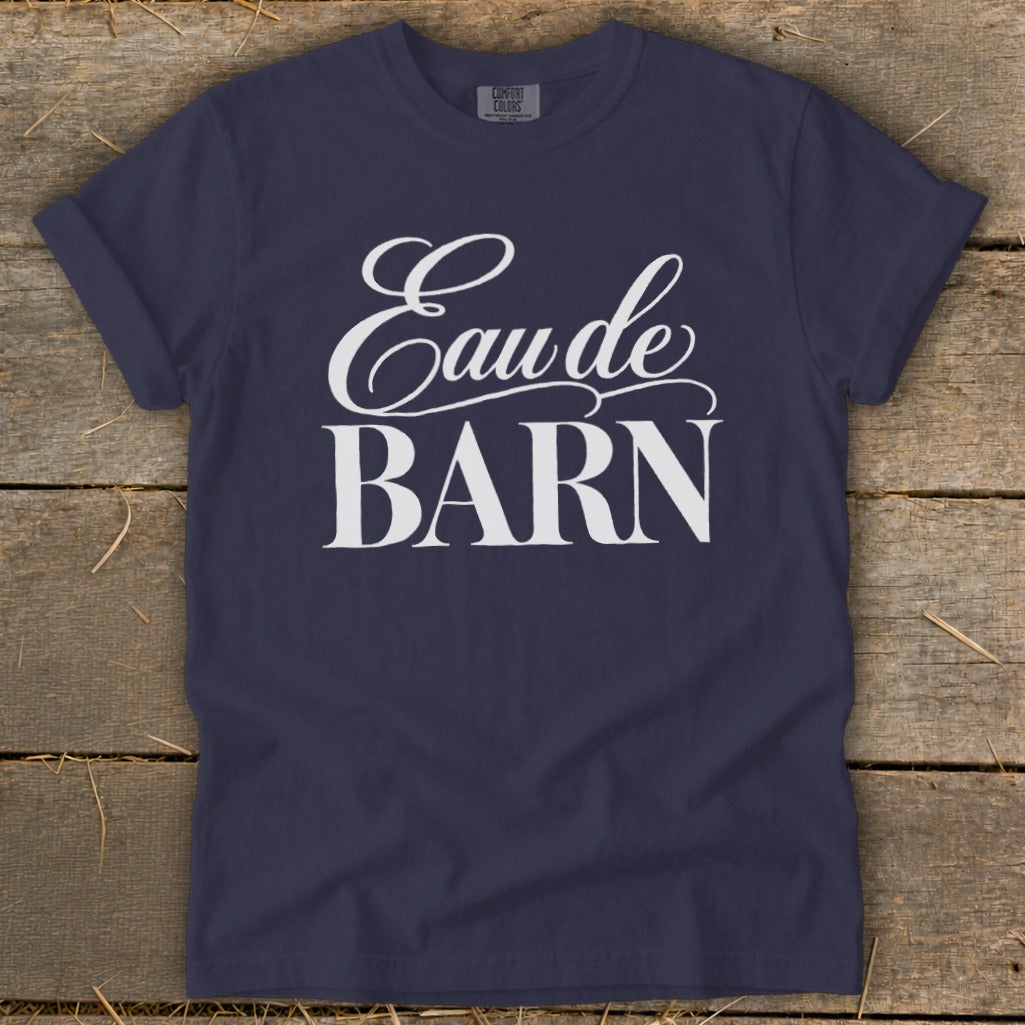 Navy t-shirt with white text reading "Eau de BARN" in script and block font.