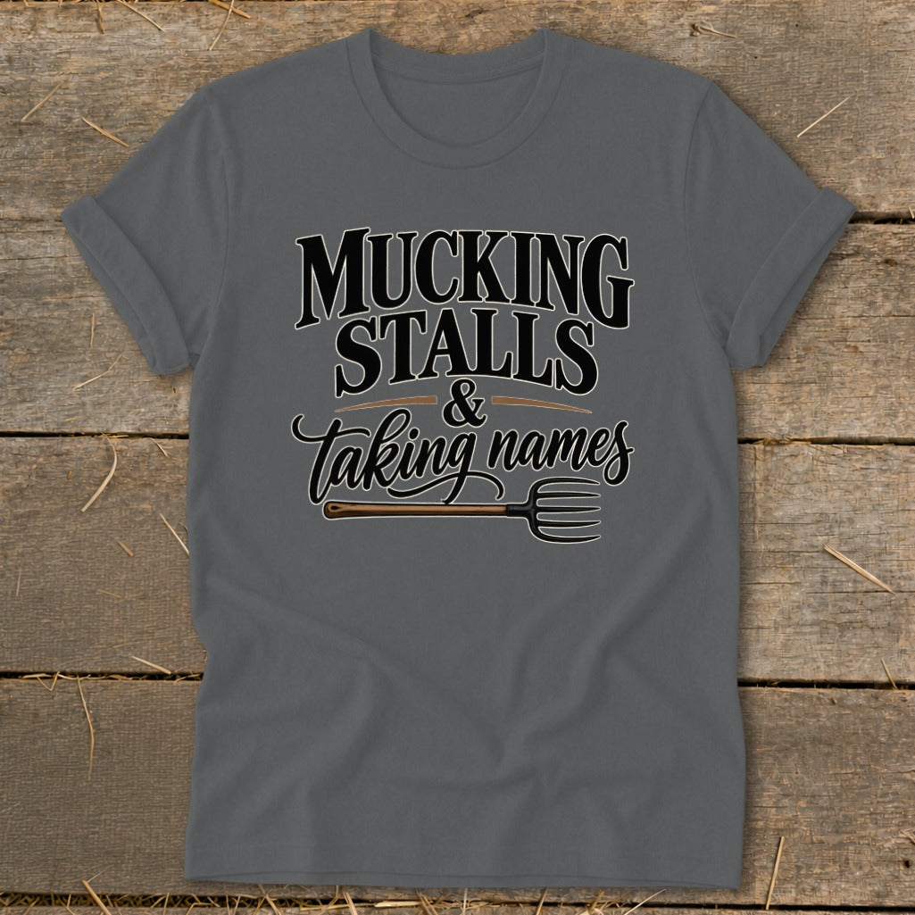 Dark grey t-shirt with "MUCKING STALLS & Taking names" and a pitchfork graphic.