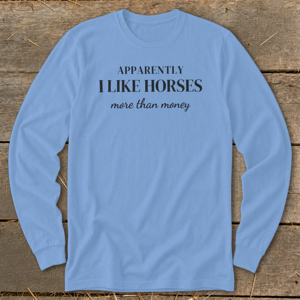 Light blue long-sleeve shirt with black text that reads "APPARENTLY I LIKE HORSES more than money".
