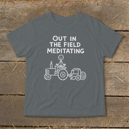T-shirt with text "OUT IN THE FIELD MEDITATING" and drawing of person meditating on a tractor.
