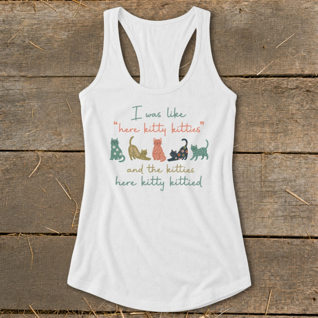 White tank top with "I was like 'here kitty kitties' and the kitties here kitty kittied" text and cats.