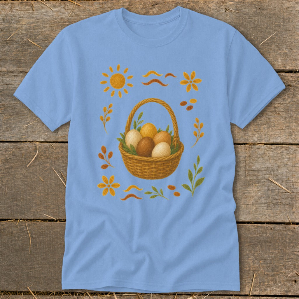 Light blue t-shirt with a woven basket of eggs and decorative sun and flower motifs.