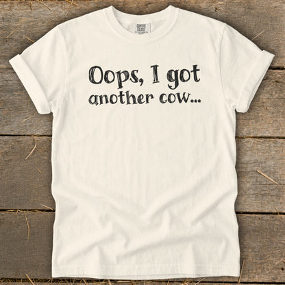 Cream t-shirt with black text "Oops, I got another cow...".