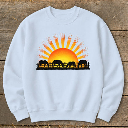 Sweatshirt with horses grazing at sunrise graphic.