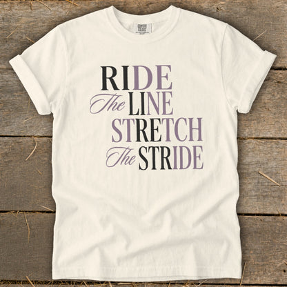 Cream t-shirt with "RIDE The LINE STRETCH The STRIDE" text in purple and black.