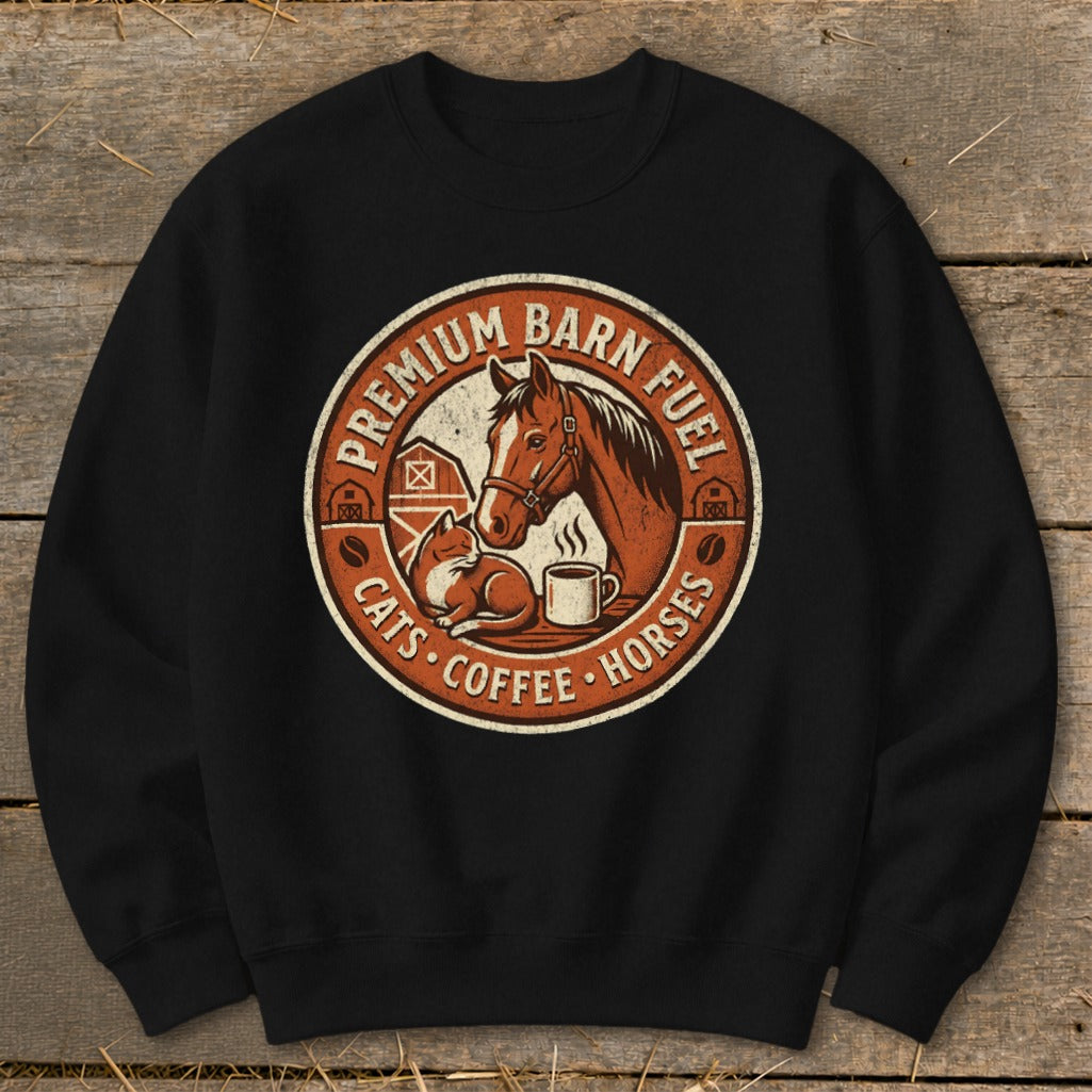 Circular graphic on black sweatshirt featuring horse, cat, coffee mug, and barns. Text: Premium Barn Fuel, Cats, Coffee, Horses.
