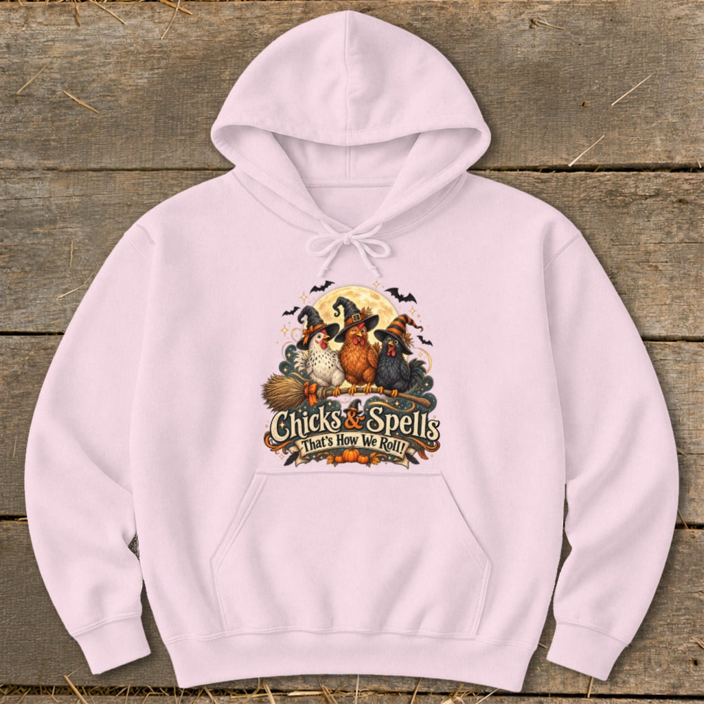 Pink hoodie with "Chicks & Spells" and three witch-hatted chickens on a broomstick.